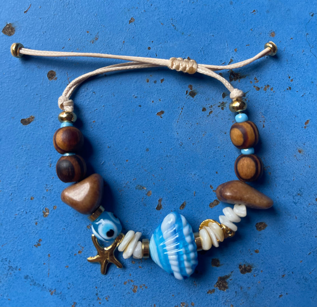 Scallop shell bracelet with wooden beads and gold charms.