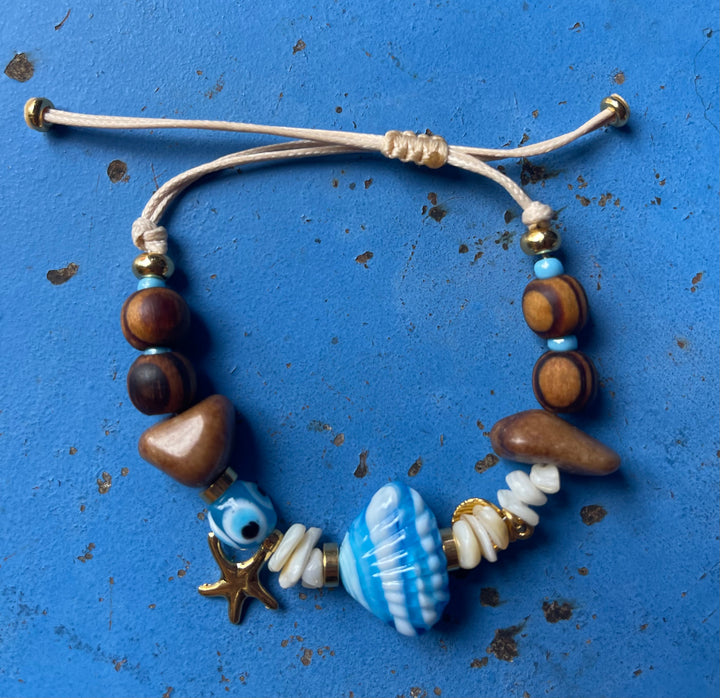 Scallop shell bracelet with wooden beads and gold charms.