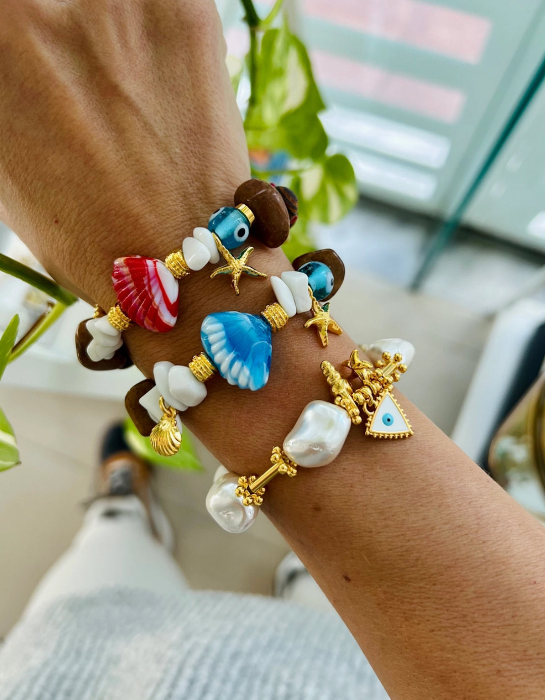 Scallop shell bracelet with wooden beads and gold charms.